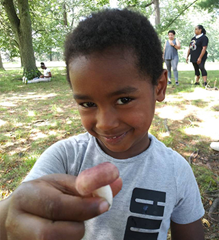 smiling young boy holding mushroom african history for kids