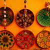 Colorful traditional woven baskets on orange wall showcasing intricate geometric patterns.